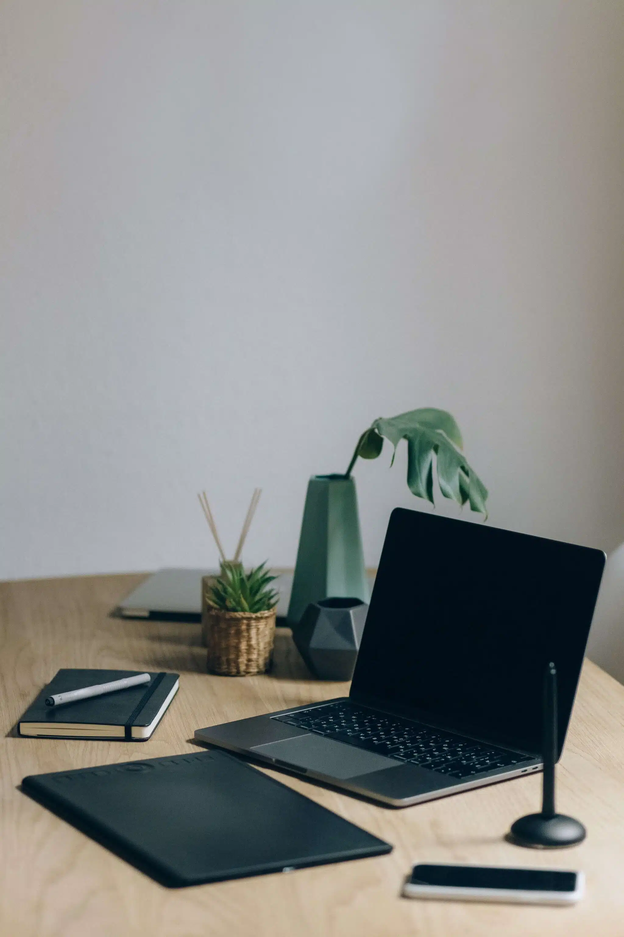 Schreibtisch mit Laptop und weiteren Utensilien